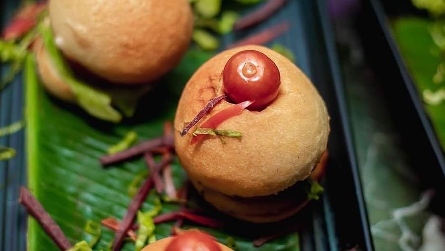 An image small buns and cherries on top served on a platter at Themis Barbecue House, NSP Pitampura