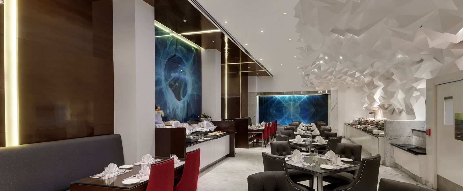 Chic lounge area with vibrant seating and artistic wall decor at The Elanza Hotel.