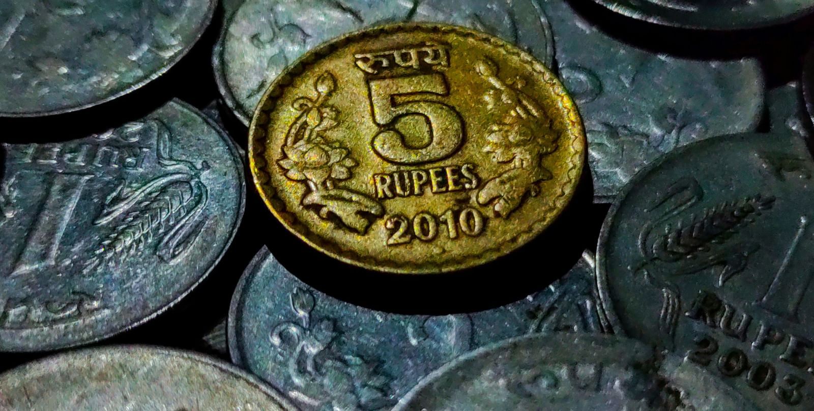A close of many indian coins on top of each other with 5 rupee coin in full view - Haldighati Museum