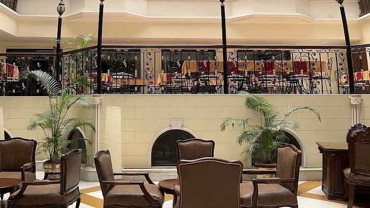 Interior of Nalapad's Hotel Bangalore International featuring a multi-story lobby with seating areas.