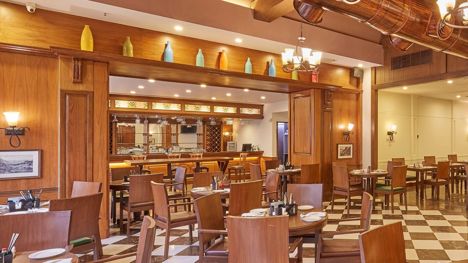 Cedar restaurant features wooden interiors and an elegant dining arrangement - Rhythm Lonavala