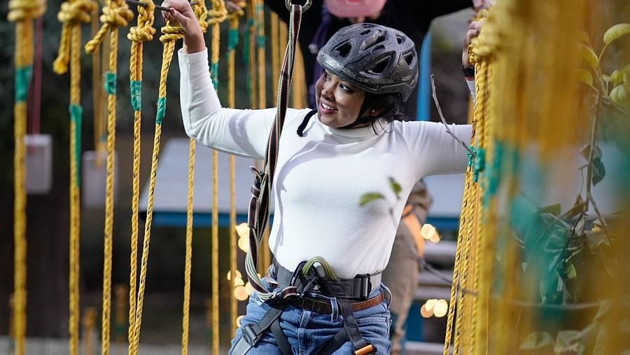 A woman walking on a Rope course at Themis Mudhouse - A Nature's Retreat Resort & Wellness