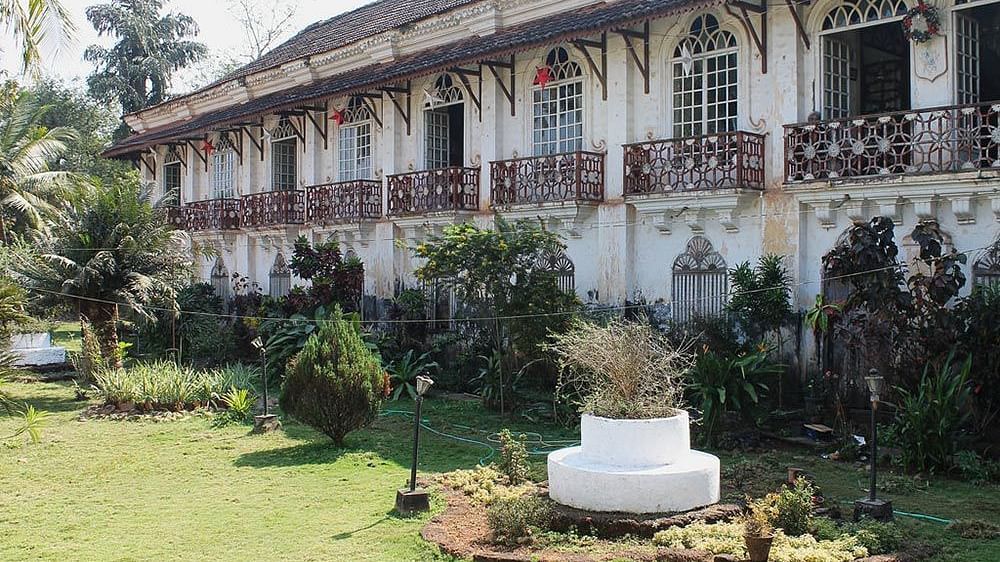 facade of Braganza Pereira House in Goa with a manicured garden in front of it