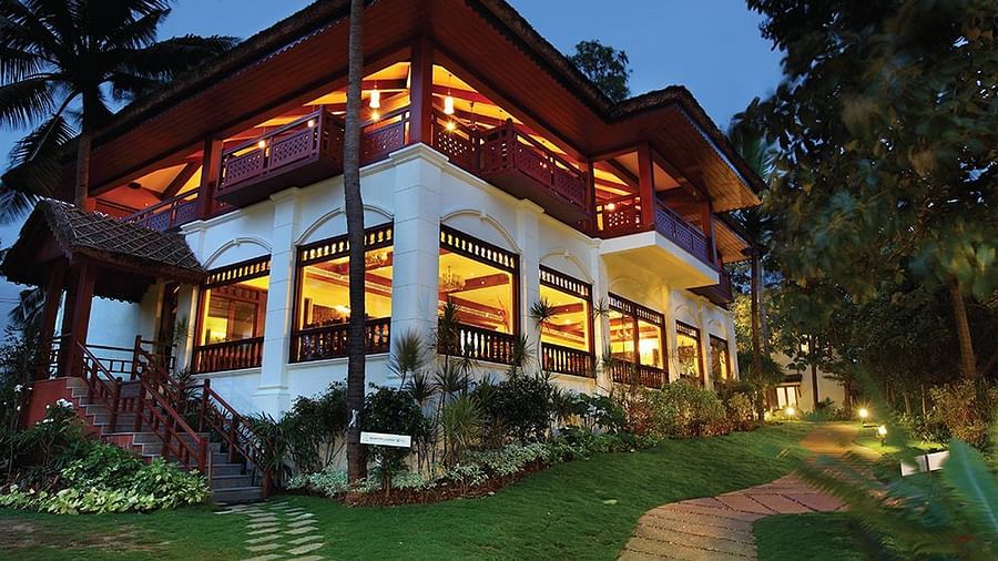 Facade view of Fragrant Nature Kollam illuminated at night.