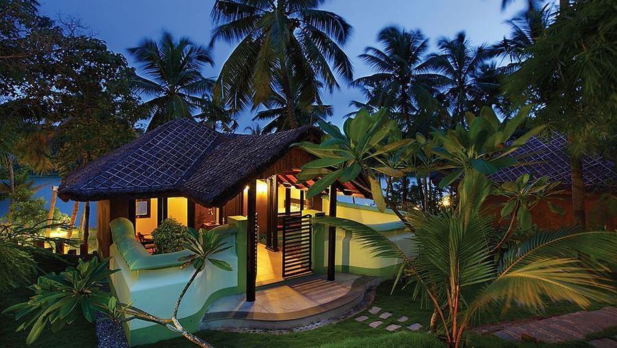 Facade view of Fragrant Nature Kollam illuminated at night.