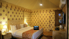 A deluxe tent room featuring comfortable bed and a modern air conditioner at Ananta Spa And Resort, Pushkar 