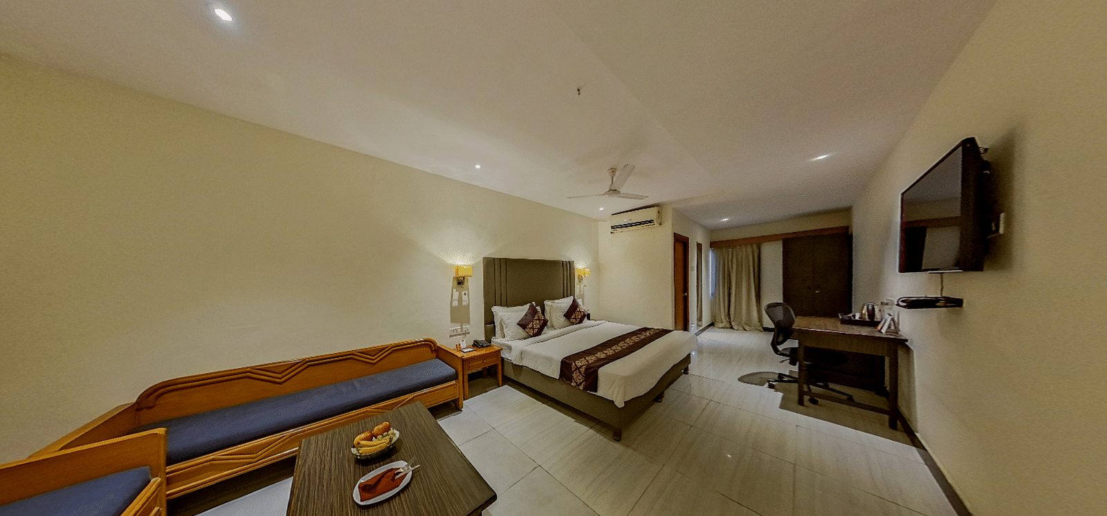 Deluxe hotel suite at Lords Eco Inn Dahej with comfortable seating area, work desk, modern interiors, and panoramic room layout
