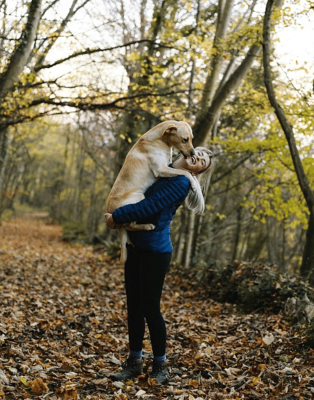 a woman dressed in athletic outfit holding a dog in her lap - Historic Tapoco Lodge