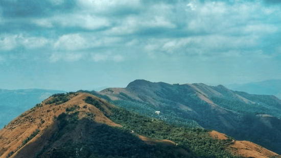 A wide view of the hills in chikmagalur with bright blue sky.