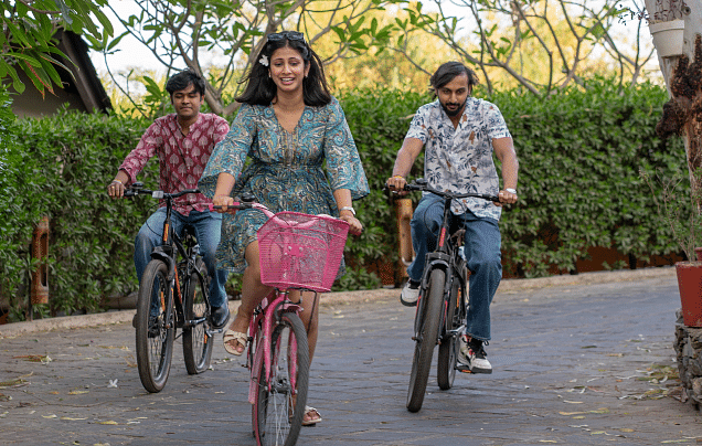 Three people riding bicycle.