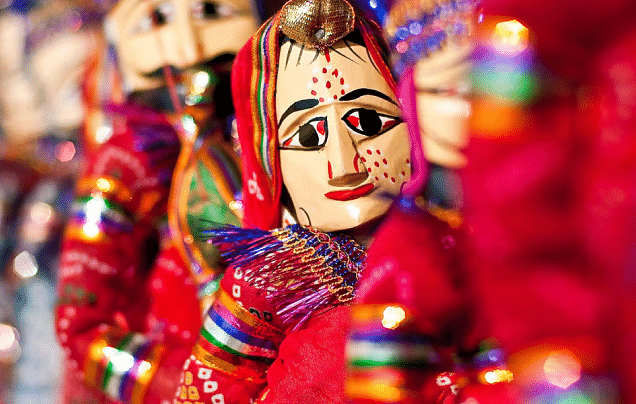 A close-up shot of traditional Rajasthani puppets, with a female puppet in focus.