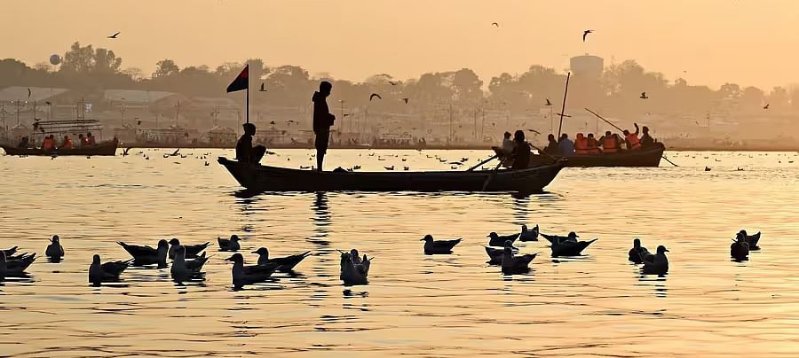 A peaceful river scene with a boat and a flock of birds, illuminated by warm golden light.