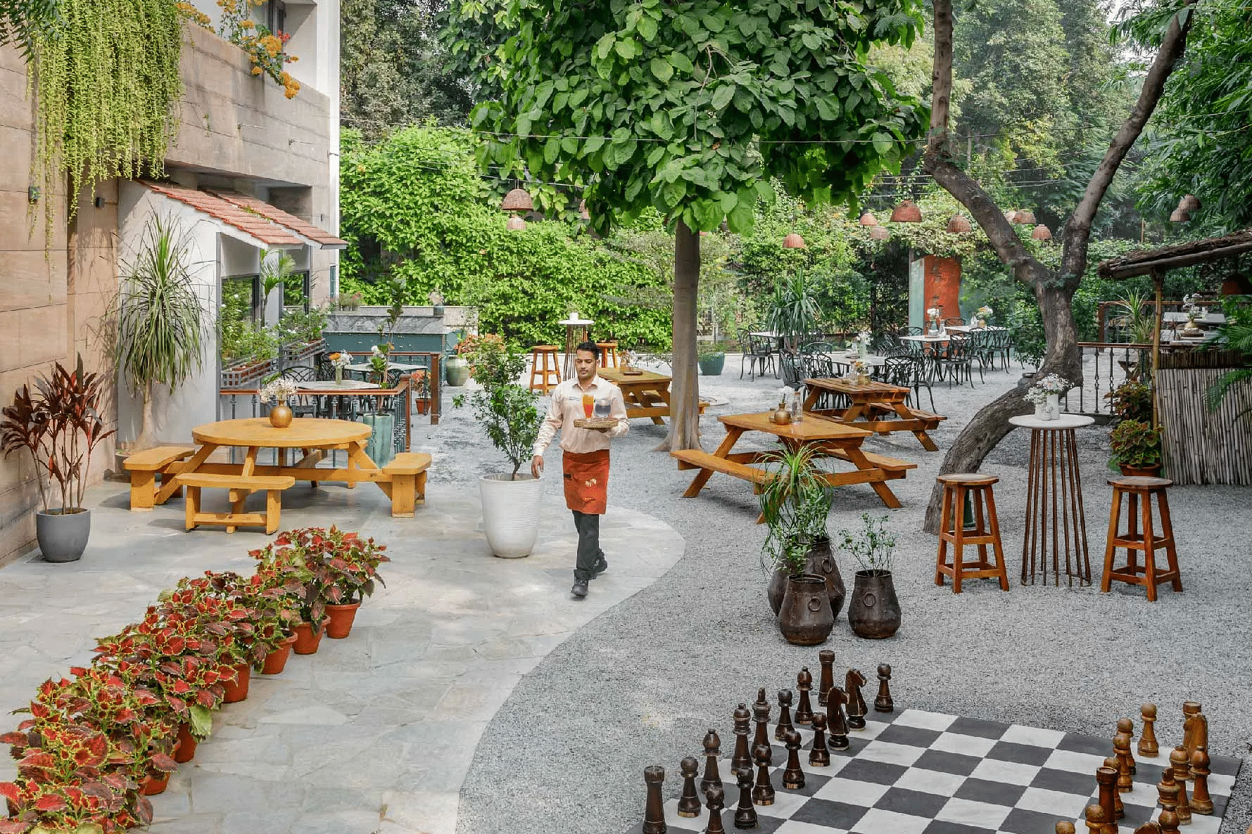 Garden area with large chessboard and seating outside a building at Karma Chalets.