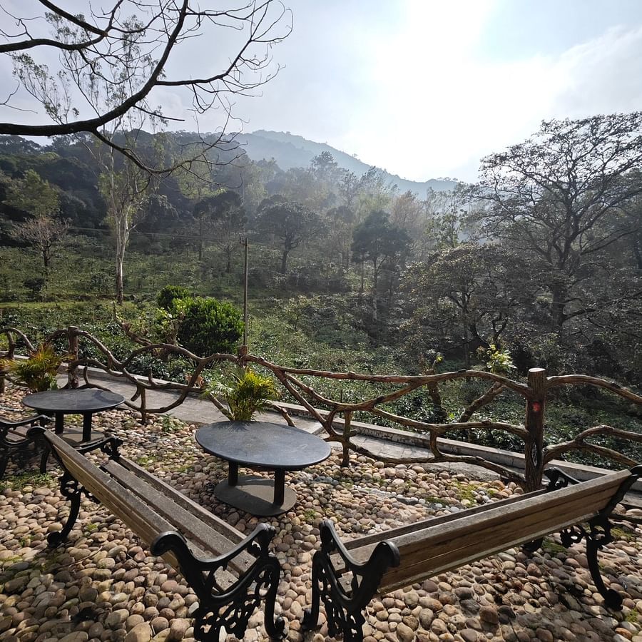 an image of outdoor space with chairs and round tables - Ibex Stays & Trails, Valparai (Mistly)