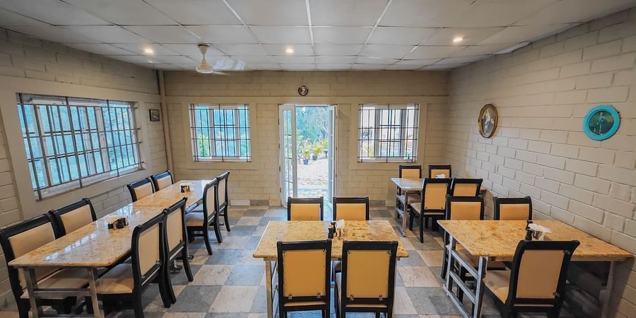 Restaurant with yellow chairs image 1  - Ibex River Resort, Pollachi
