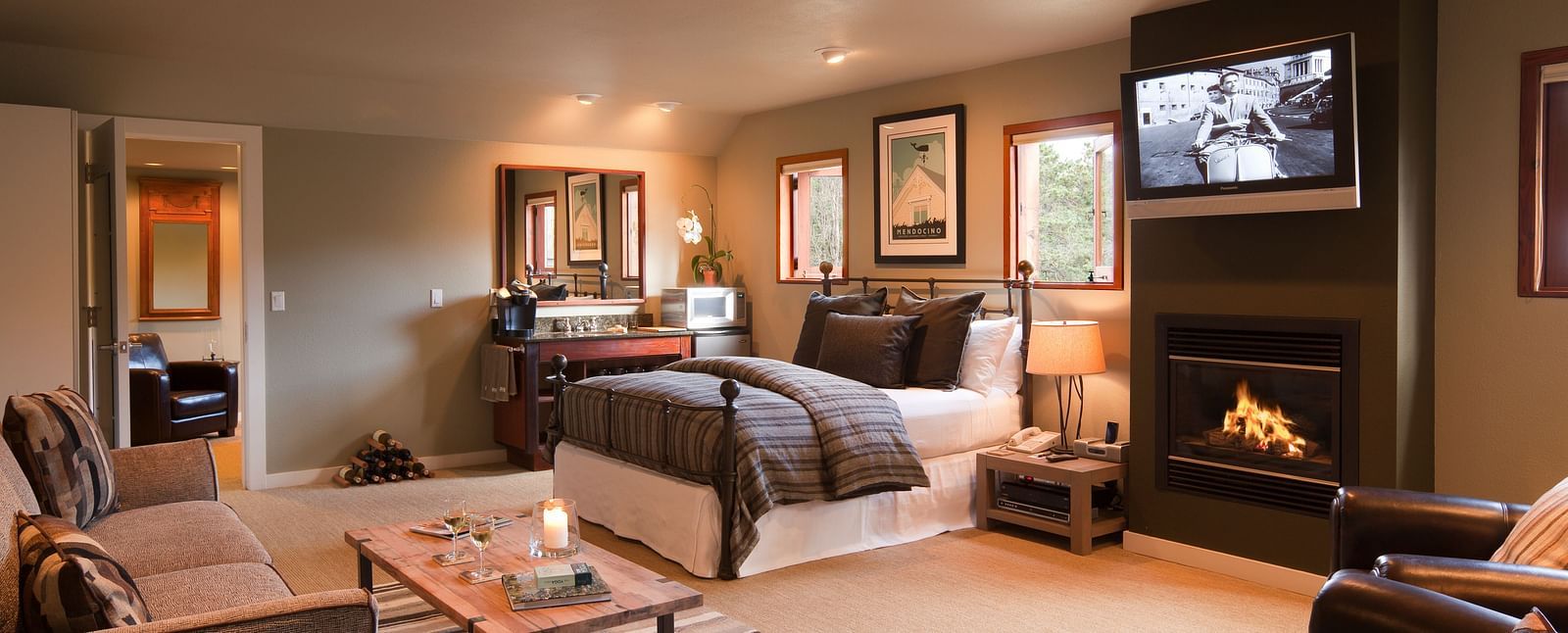 Meadowview Suite featuring a couch, a teapoy, a plush bed, a wall-mounted television and a leather couch - Brewery Gulch Inn & Spa