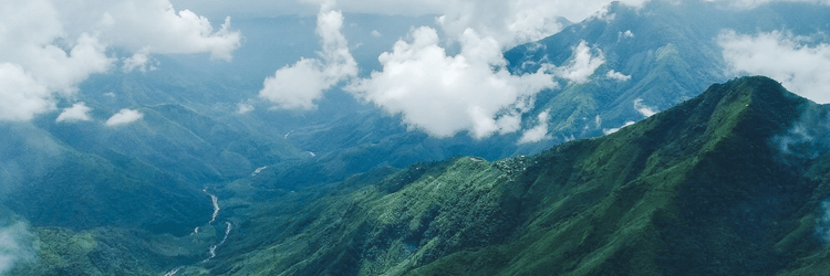 view of the green hills with clouds floating 