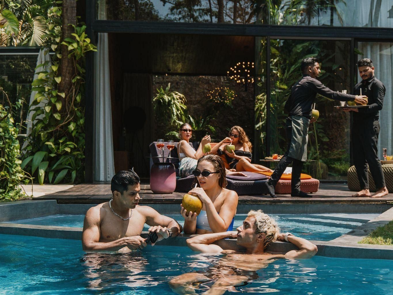 Picture of a few people soaking in the pool and a few people in the background