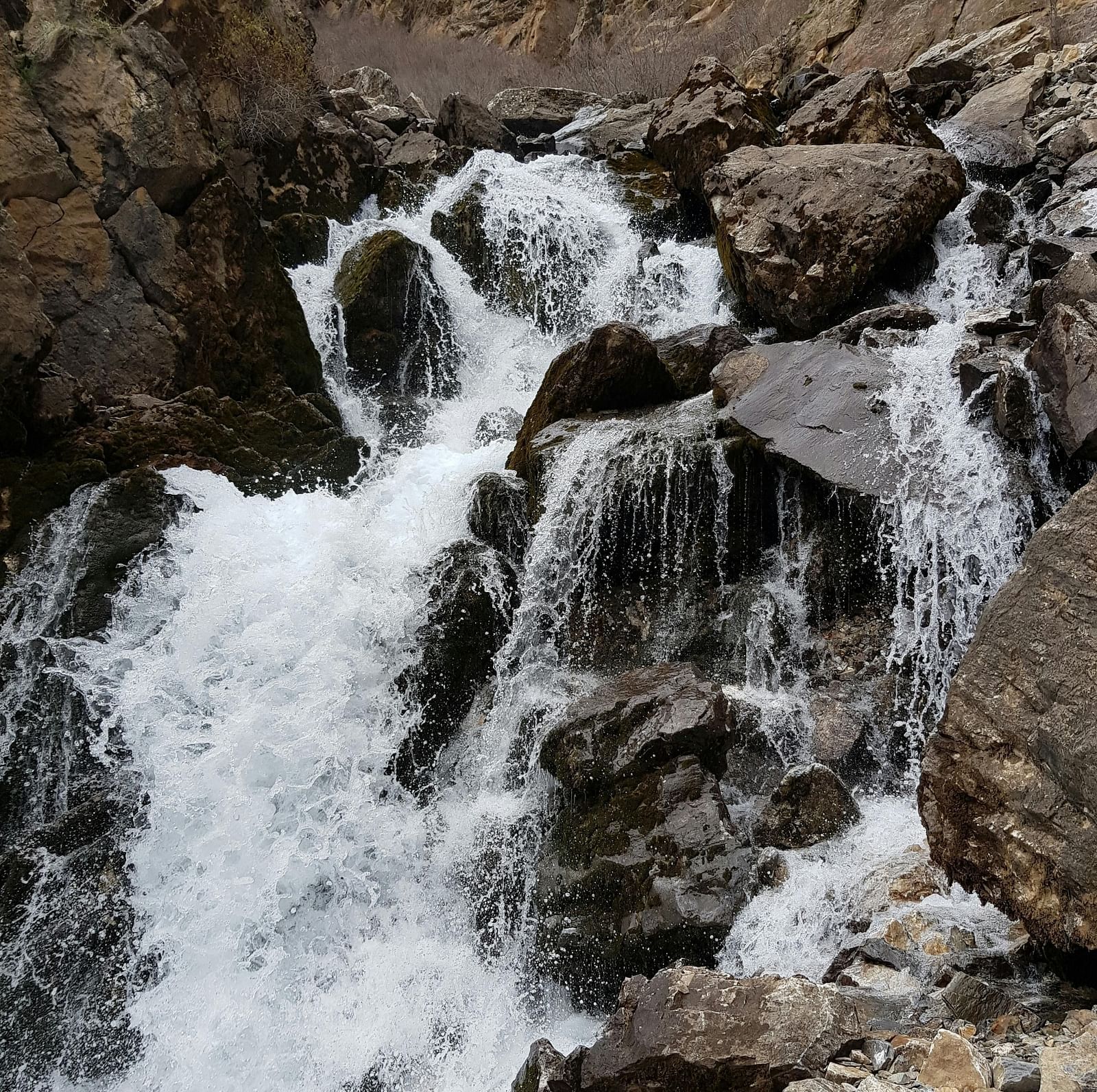 An image of a waterfalls with water pouring down on to rocks