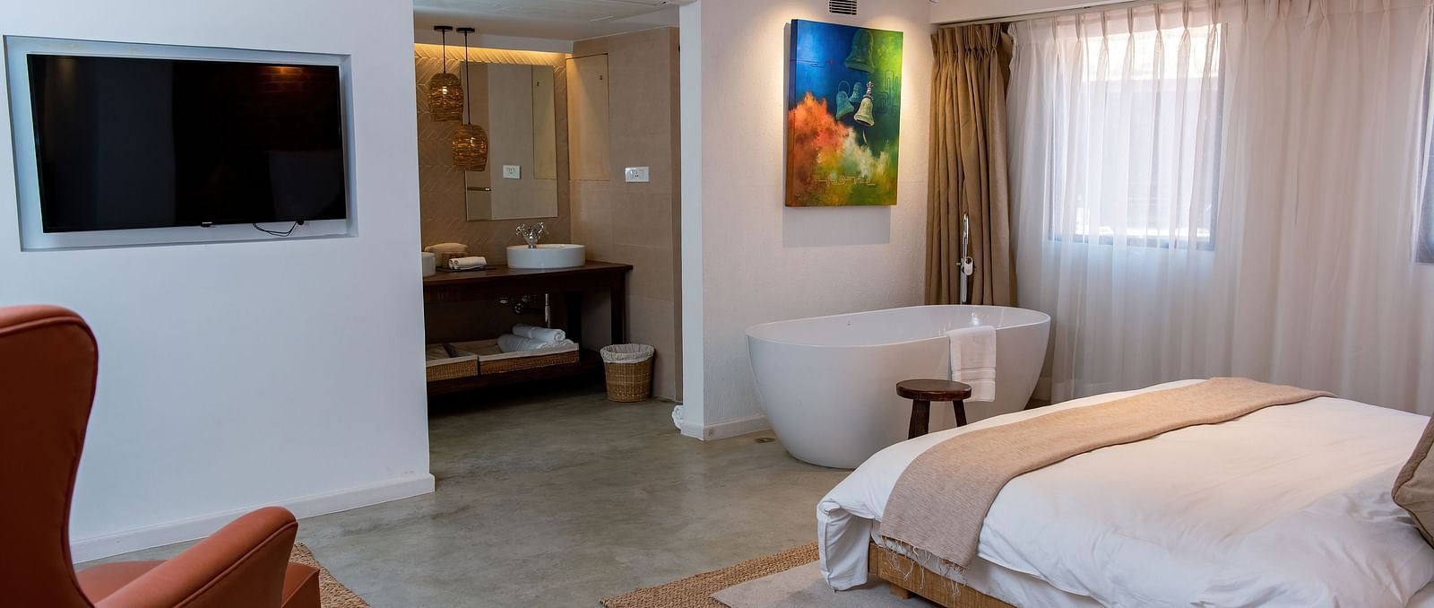 The Nepali Suite featuring a bed, flat screen TV, a sofa and a bathtub - The Nanee