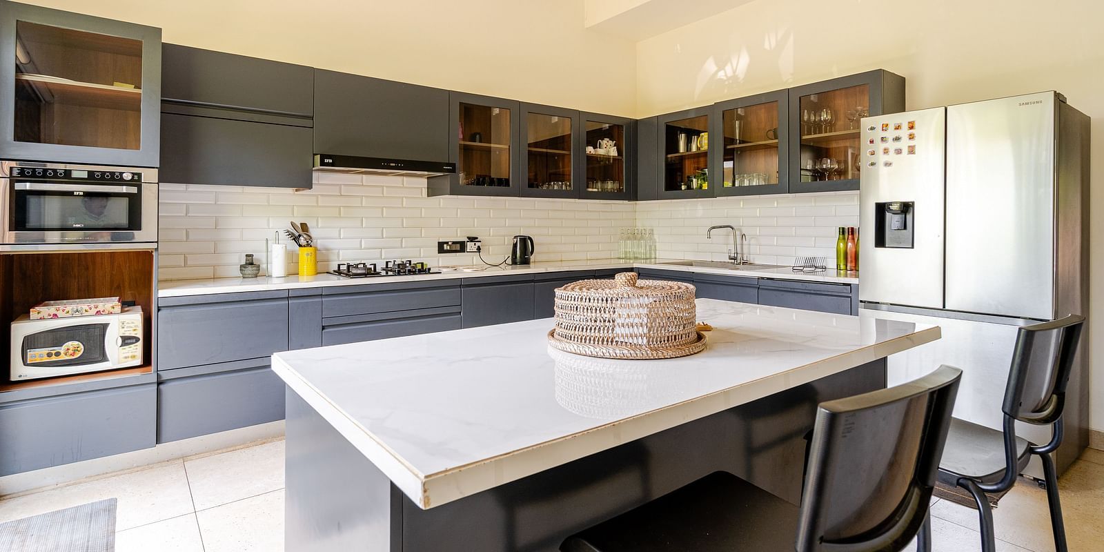 Fully equipped kitchen at Lindsay Manor with an island counter, bar stools, built-in appliances, and upper and lower cabinets.