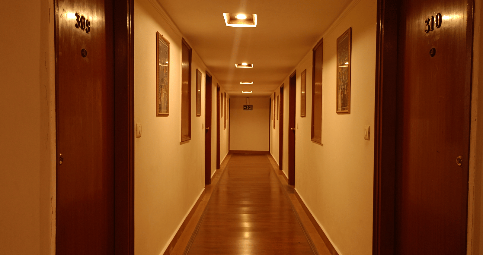 Corridor at Hotel Gold, Panipat showing a long hallway with room doors on both sides.