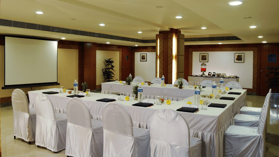 A well-lit conference hall of Lords Plaza Ankleshwar with U-shaped seating style featuring audio visual systems