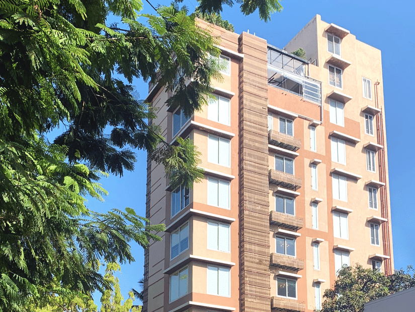 Facade of Theory9 Service Apartments in Bandra during the day with trees in view.