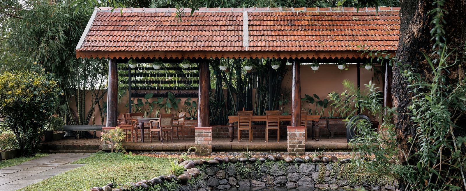 A facade image showcasing the pond at BluSalzz Villas - Muhamma Resort, Alleppey and the outdoor seating area of the restaurant