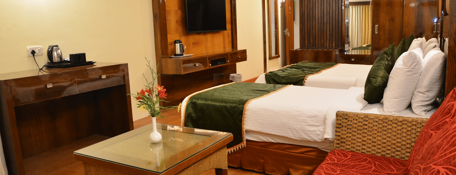 A premium twin bedroom with modern decor, wooden finishes, and a glass coffee table for added comfort - Benzz Park, Kodaikanal