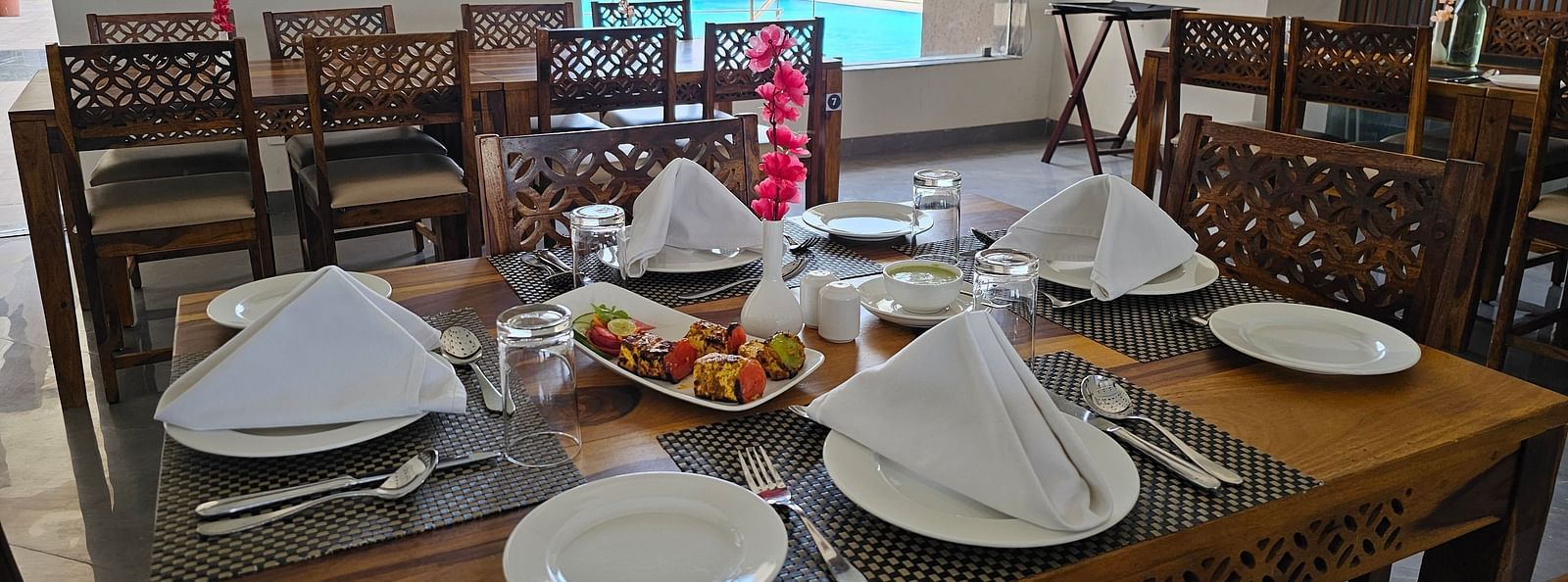 A dining table is laden with various food items and cutlery - Bamboo Saa Mulberry Resort, Pushkar