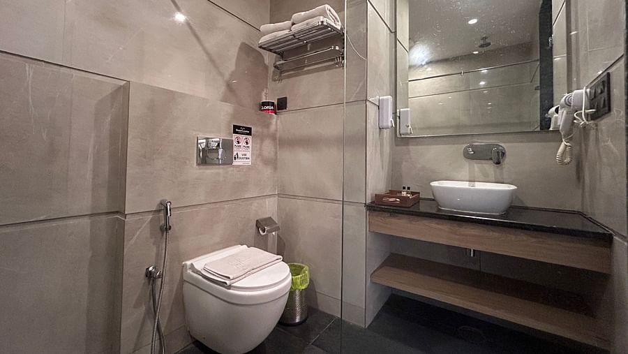 A shot of a washroom fitted with wash basin, commode, and toiletries - DLS Grand Luxotica, Dehradun