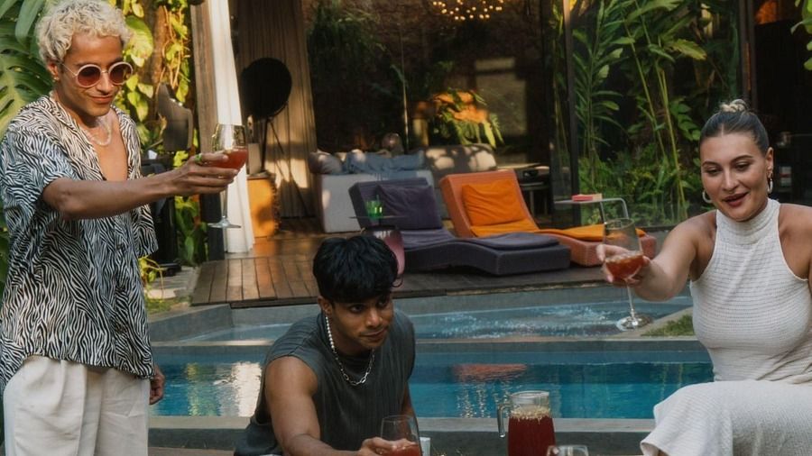 A picture of a few people having drinks next to a swimming pool