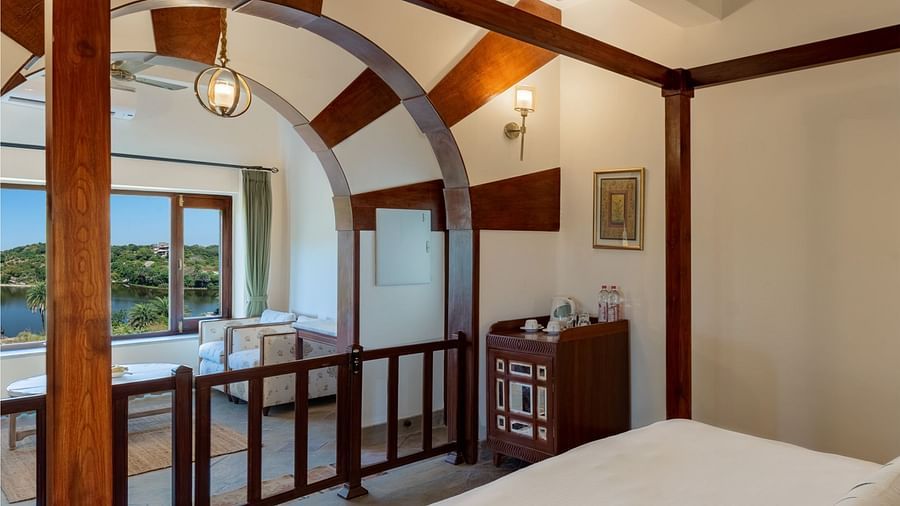 A king bed with pillows on it and white sheets in the Villa - Chunda Shikar Oudi