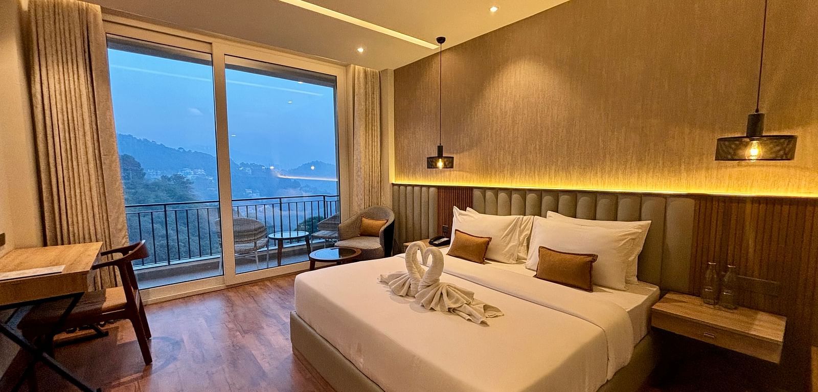 Elegant bedroom with large windows, wooden accents, and a scenic balcony view – ARNISA Boutique Hotel