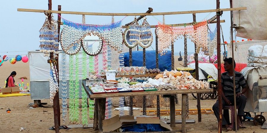 A stall selling items at a beach with blue sky in the background