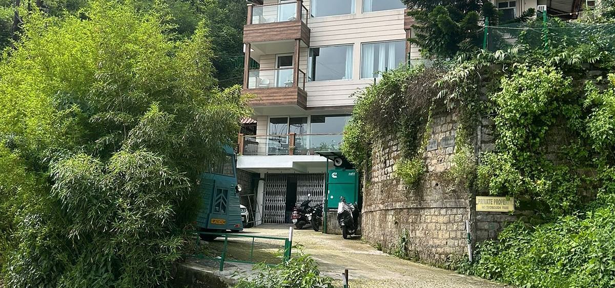 Facade view of SOUTHGATE KASAULI BY ZENQ with bush covering them at the front. 