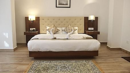 A double bed with side tables and lamps inside Super deluxe room - Ecotel Chiminda