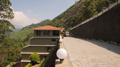 Abad Copper Castle exterior view from a low angle, showing a paved driveway curving uphill.