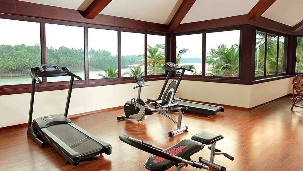 Gym with all the equipment neatly arranged, ample space around, and mirror walls with lighting