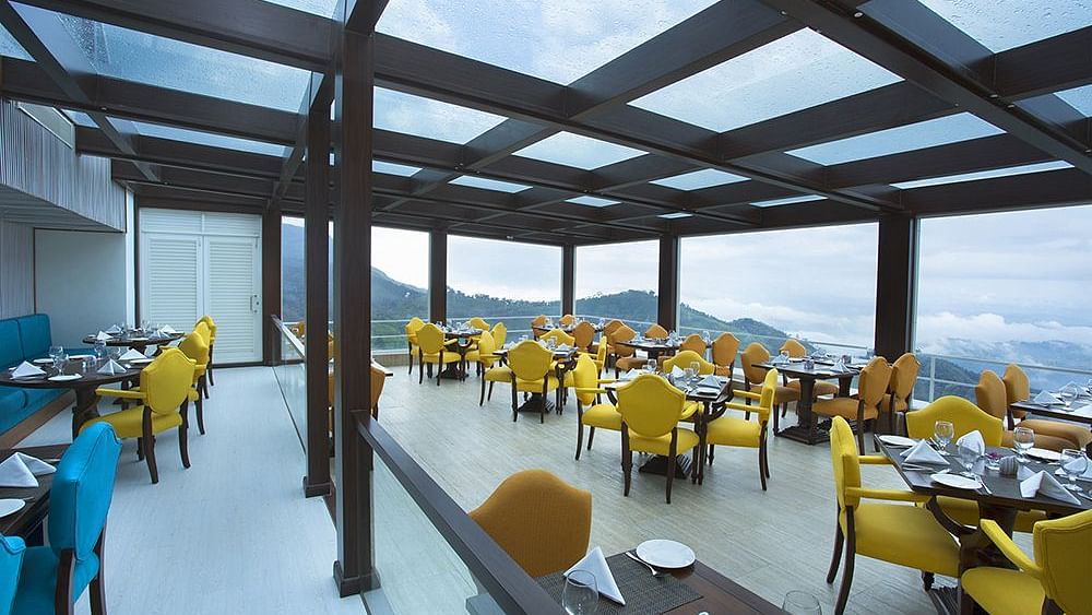 Mountain and sky view from the glass-roofed restaurant at Fragrant Nature Munnar
