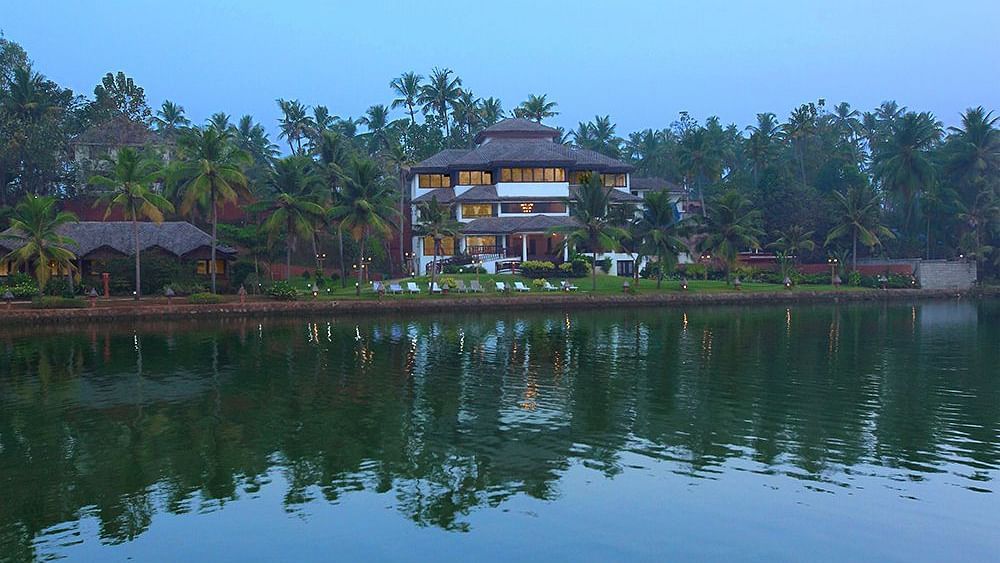 Facade view of Fragrant Nature Kollam with its reflection on the lake.
