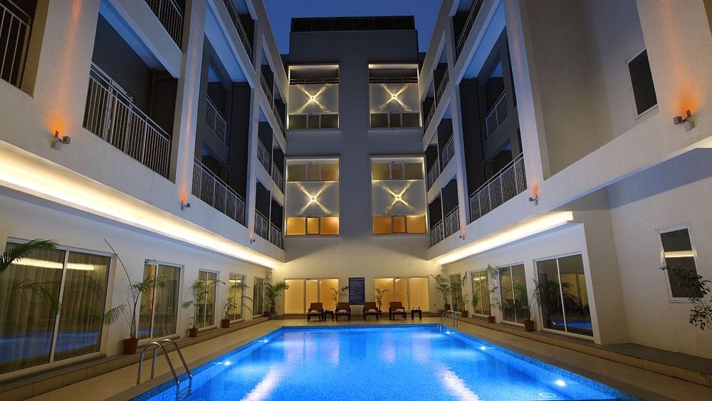 Swimming pool in the night with the lights on - Starlit Suites, Kochi