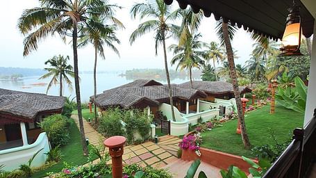Facade view of the building with coconut trees surrounding the area - Fragrant Nature Kollam