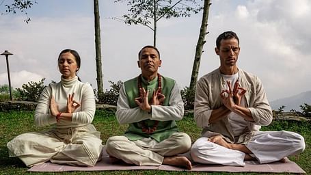 A front shot of three people sitting on the grass and meditating | Kavya Resort & Spa, Nagarkot