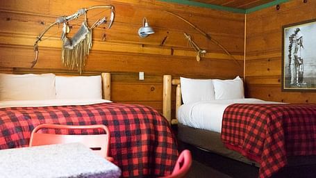 A wooden cabin with twin beds at Shaver Lake Village Hotel.