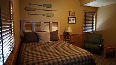 A room with a double bed and wooden oars hung on the wall behind it at Shaver Lake Village Hotel.