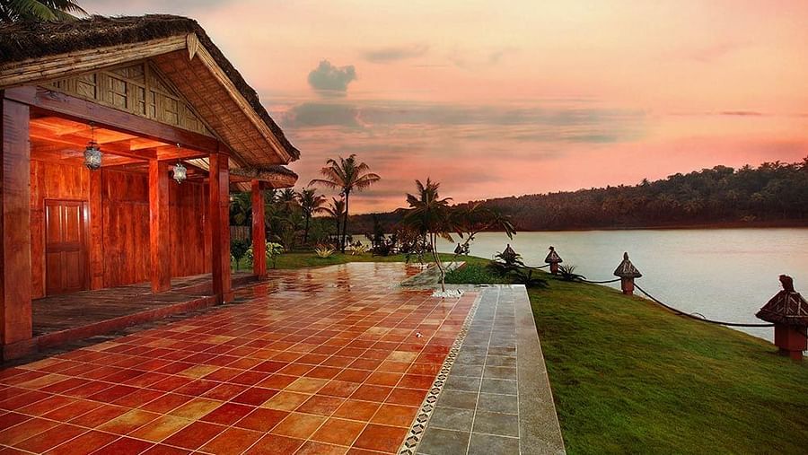 Facade view of the hotel with trees surrounding the lake.