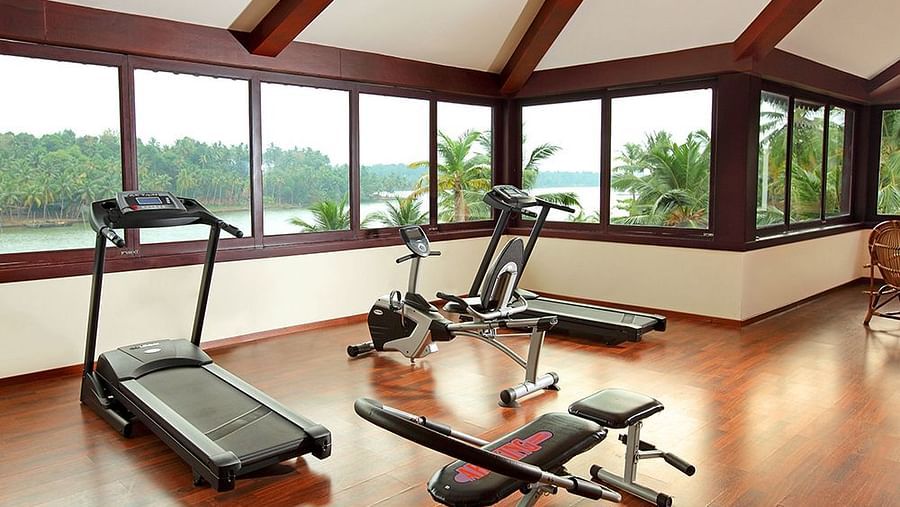 Gym with all the equipment neatly arranged, ample space around, and mirror walls with lighting