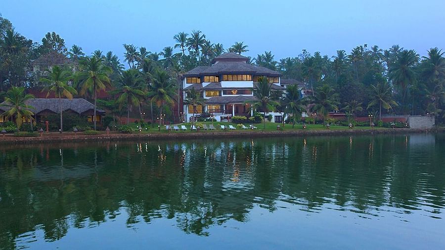 Facade view of Fragrant Nature Kollam with its reflection on the lake